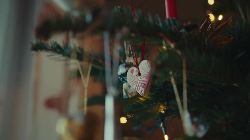 A handmade ornament hangs on a christmas tree