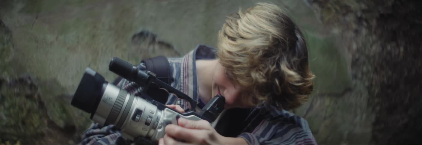 A teenager is using his camera