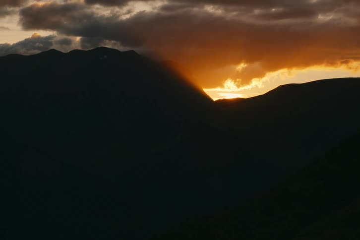 The sun is rising behind the mountain
