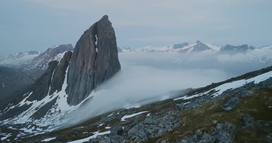 The clouds sit on the summit of the mountain