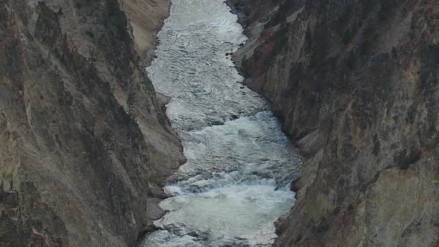 A river with a strong current in a valley between mountains