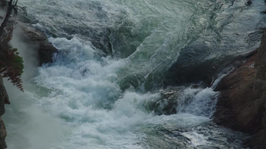 River flows over rocks near plants