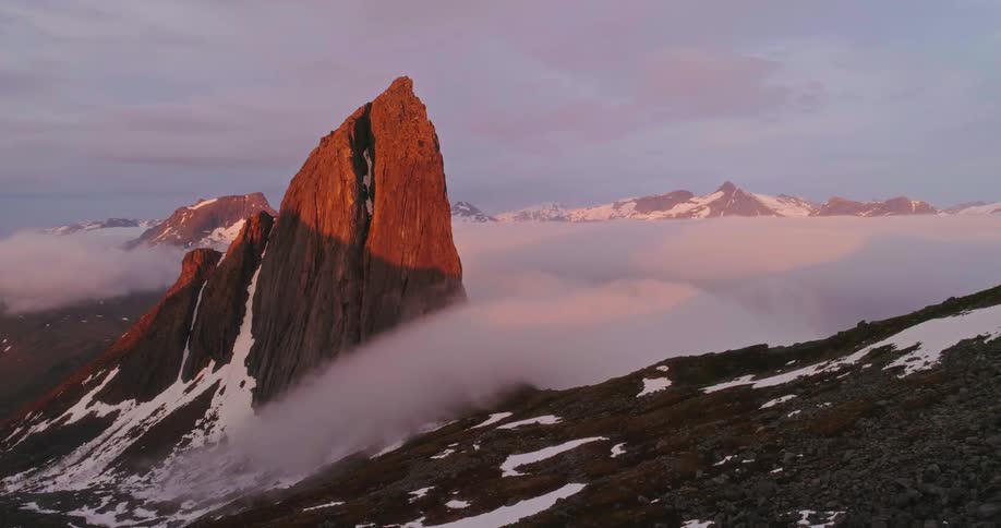 Person on top of a rock enjoying the snowy mountain view