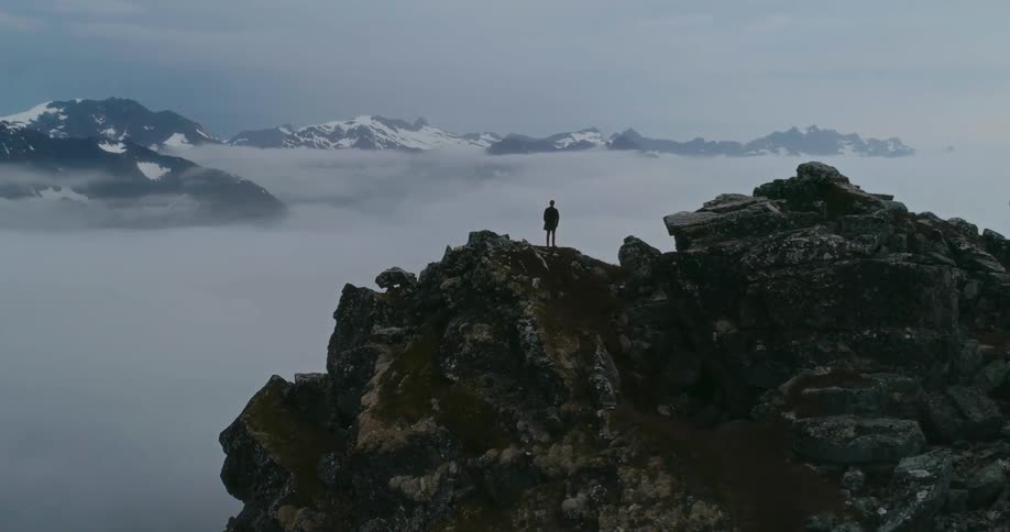 A person is standing on the peak of the mountain