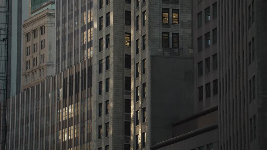 The facade of a large gray apartment building with several windows