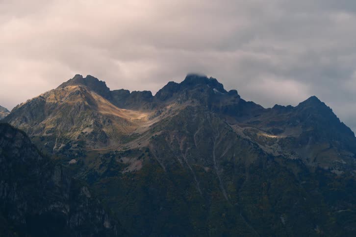 Clouds slowly drift over mountain tops and create shadows