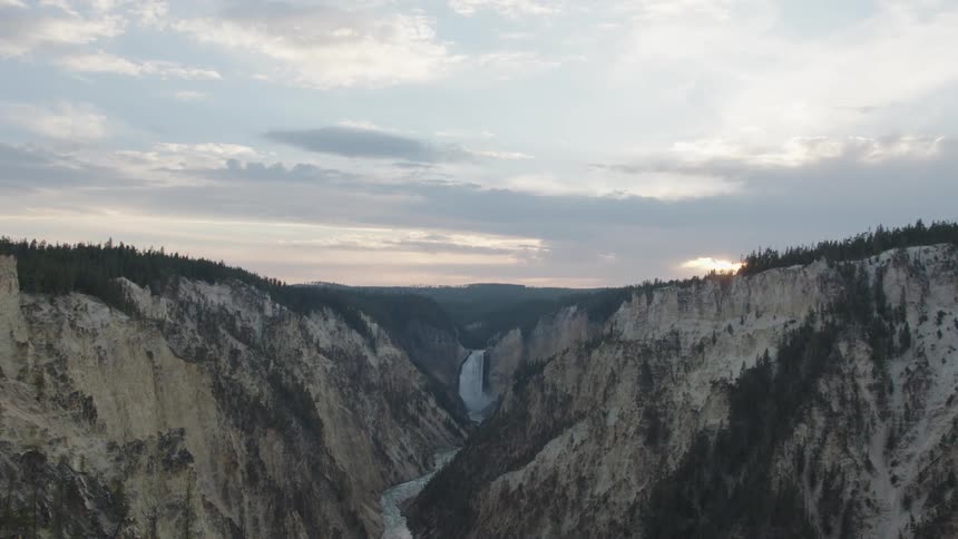 A river formed in a valley between stone mountains with some trees on top