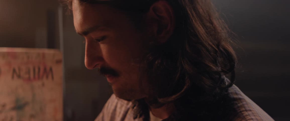 Portrait of a long haired man working in an indoor workshop space