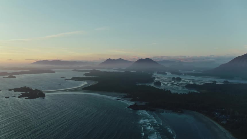 Aerial of several islands and beaches on a Pacific coastline at dusk
