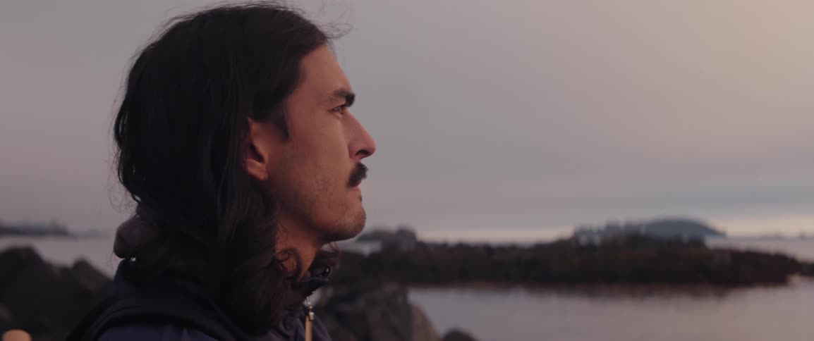 A man is looking out over the ocean in the evening