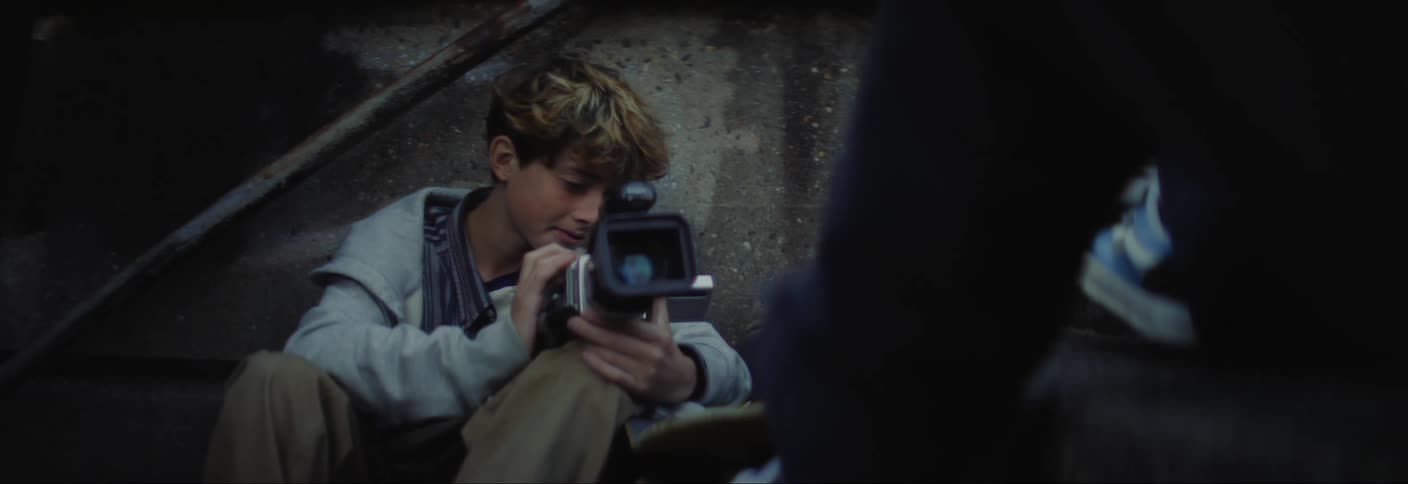 A teenager is talking and filming with his camera
