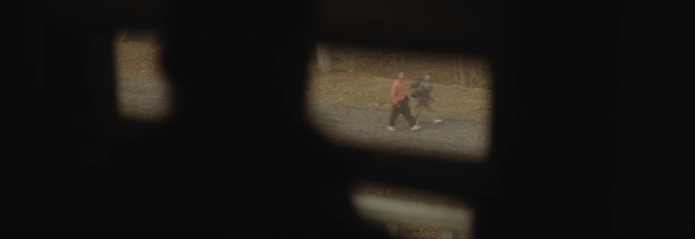 Silhouette of a person looking out the window two people walking