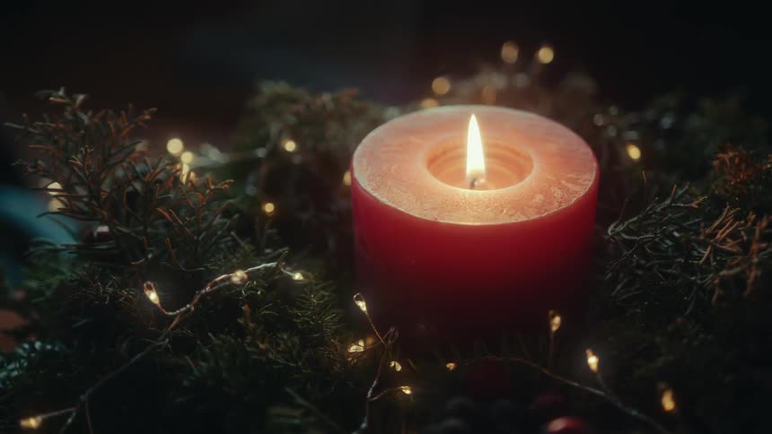 Red candle lit in the middle of a wreath