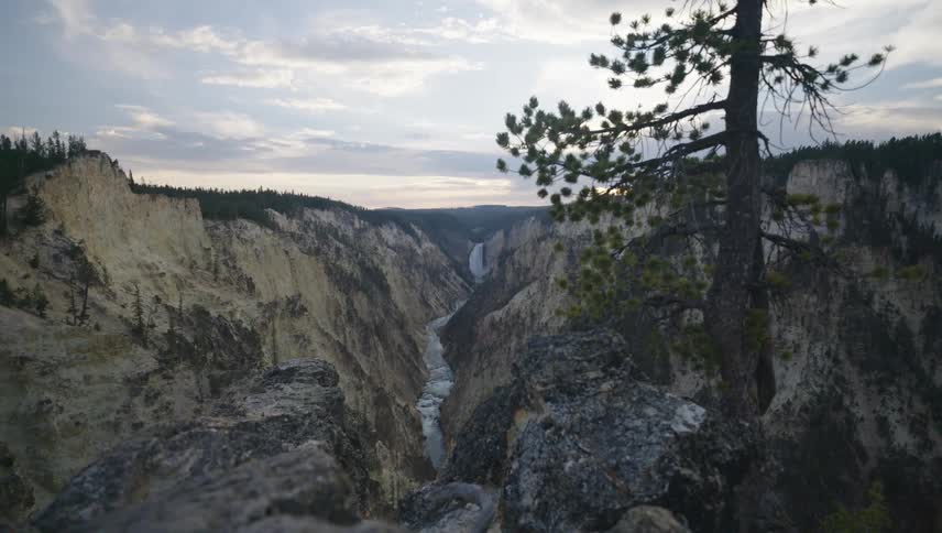 A long distance shot of a tall waterfall trailing down a mountain