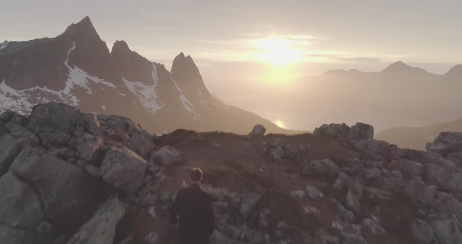 A man hikes to to the peak of the mountain