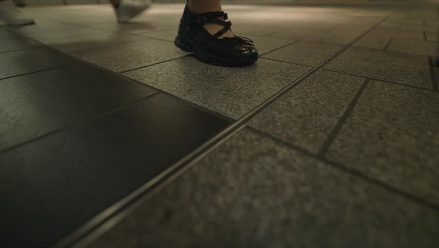 Floor level view of people walking and their shoes