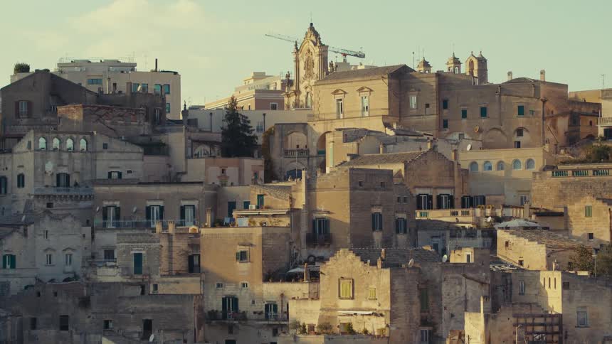 A captivating scene of a historic town nestled on a hillside with a multitude of buildings showcasing a rich tapestry of architectural styles bathed in the warm glow of the setting sun