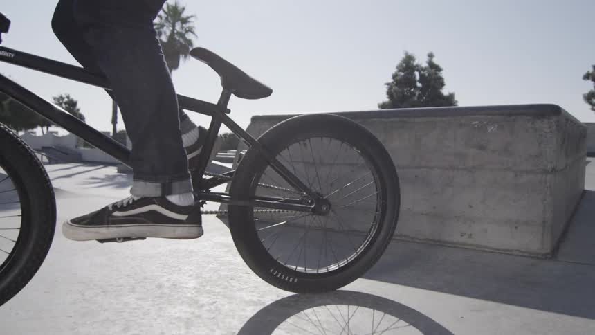 A bmx style bike with someone getting on it