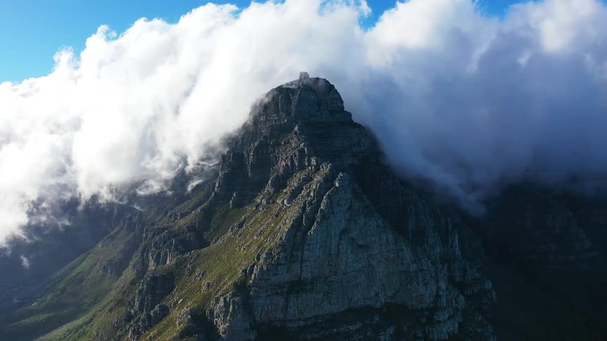 Large clouds cover the peak of the mountain