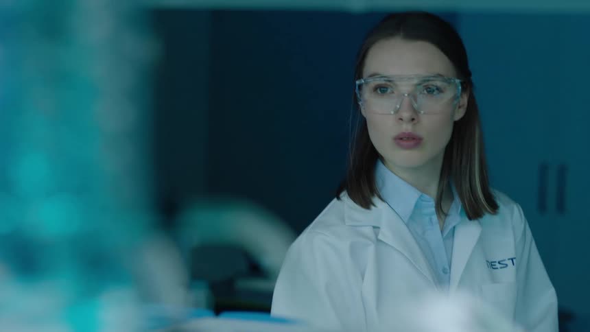 Woman in lab coat and glasses working in a laboratory