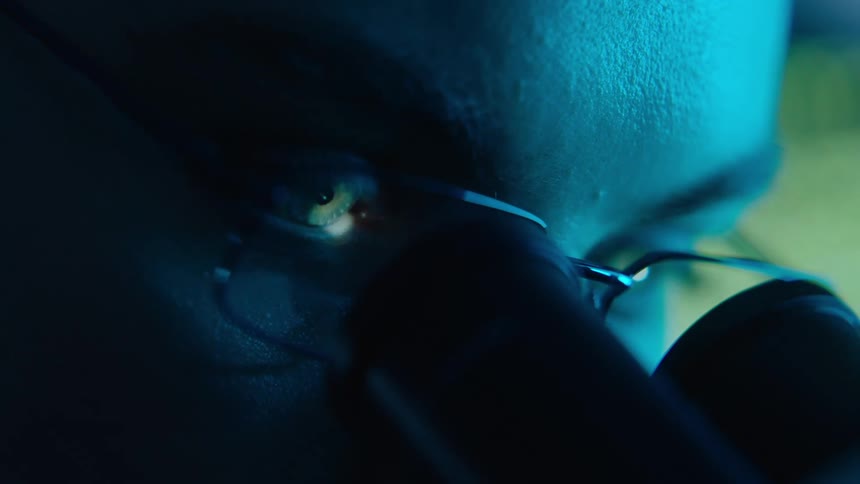 Close up of a womans face using a microscope