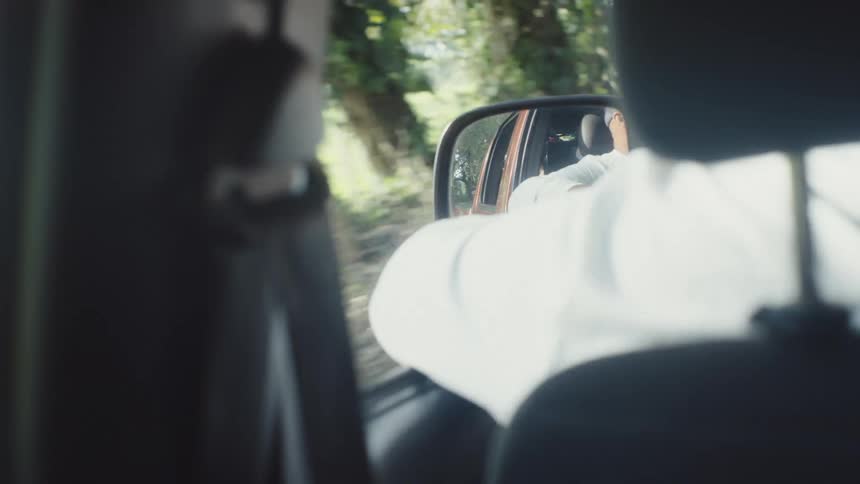 Man is driving his vehicle through a wooded landscape