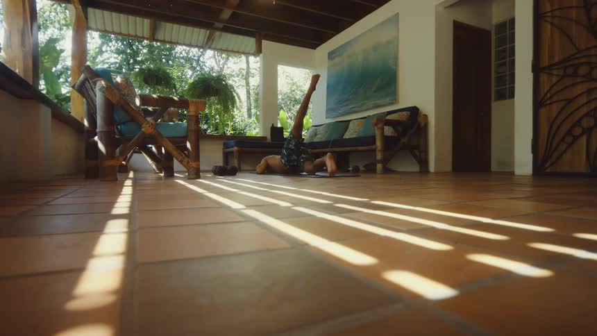 Man crouching on the floor raising his leg up stretching