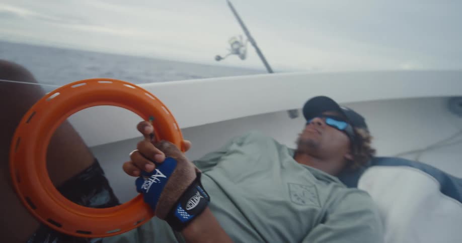 A man holds a fishing line as he rests in the boat
