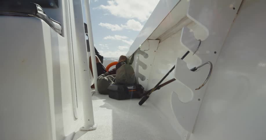 Person lying on a boat moving through the sea