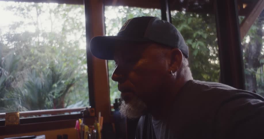 A clip of a man putting on a black cap
