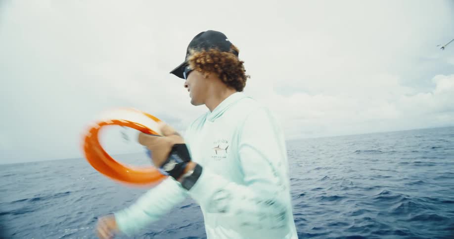 Fisherman in a boat pulling a fishing line