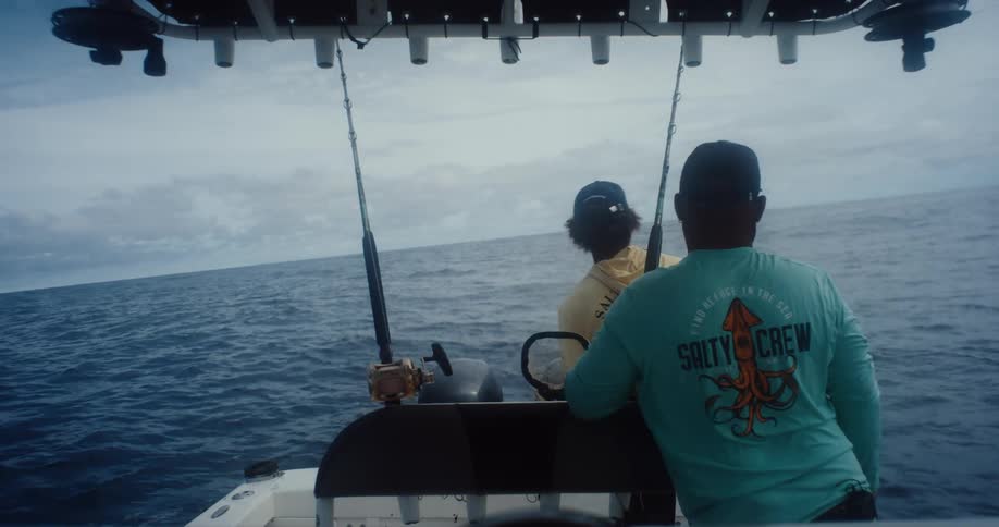 Two fishermen in a boat in the vast blue ocean