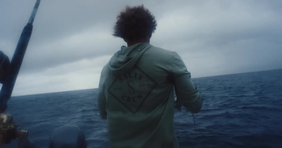A man is pulling fishing line on the boat