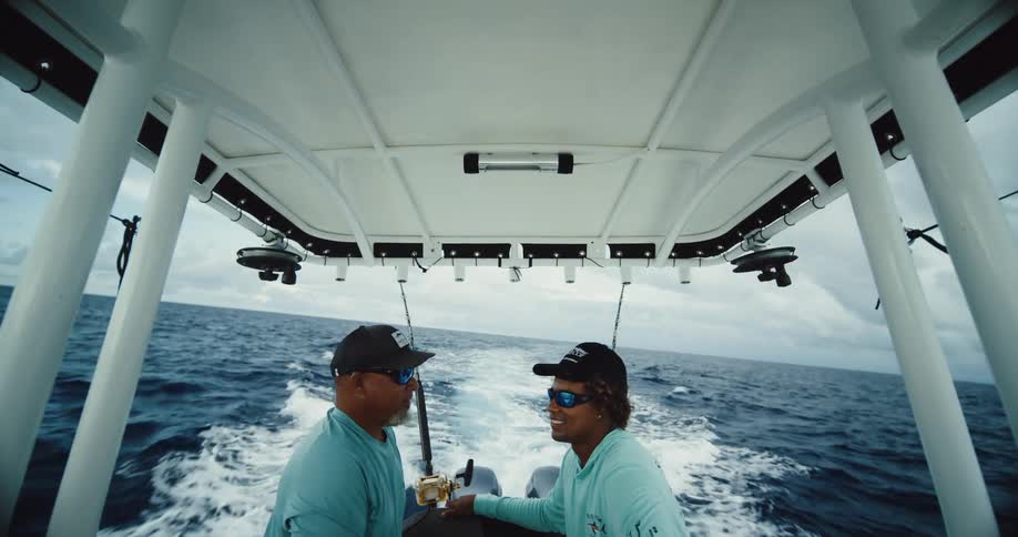Two fishermen in a boat moving through the sea