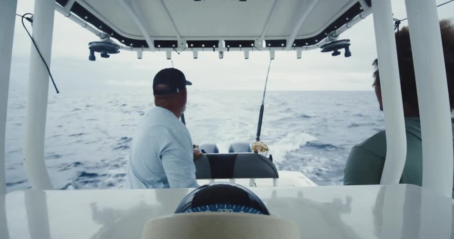 Two people on a small fishing boat in the ocean