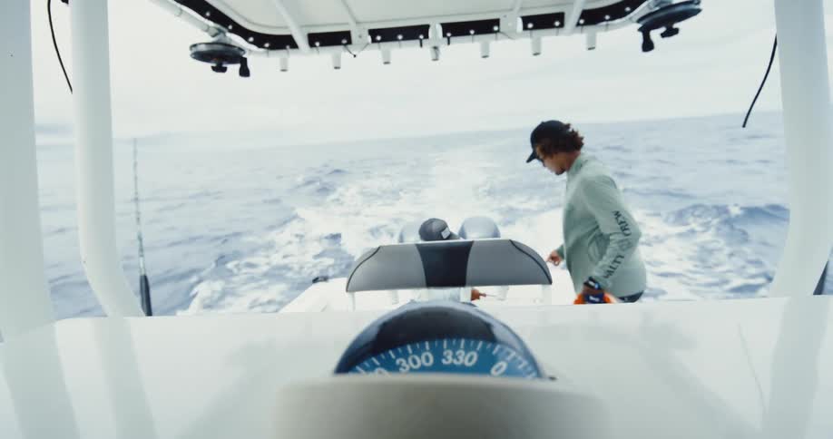 A man talks and walks on the fishing boat as it is moving