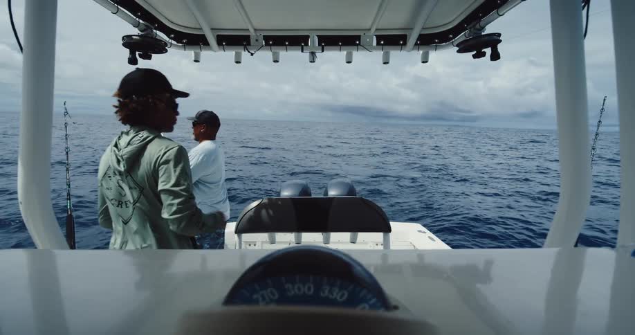 Two men are fishing on a boat on the ocean