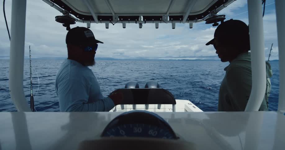 Two fishermen in a boat in the middle of the sea
