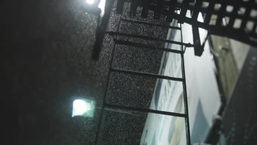 Snow blowing against a building on a winter night