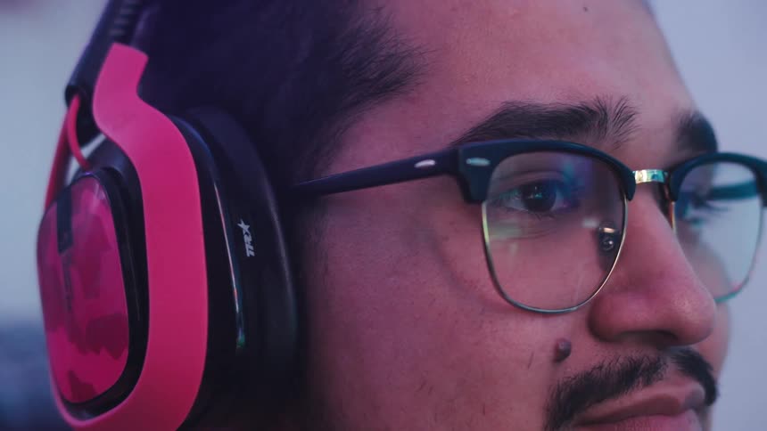A man smiles while listening to his headphones