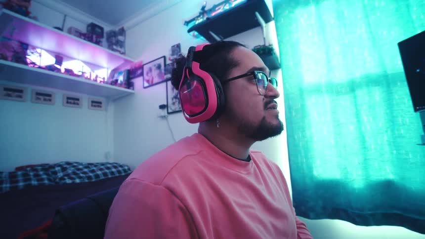 Man sitting in bedroom with headset playing games