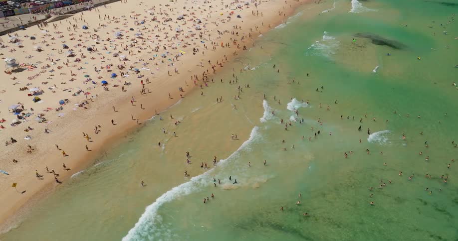 Aerial panorama of a summer season on a beach with a crowd of bathers