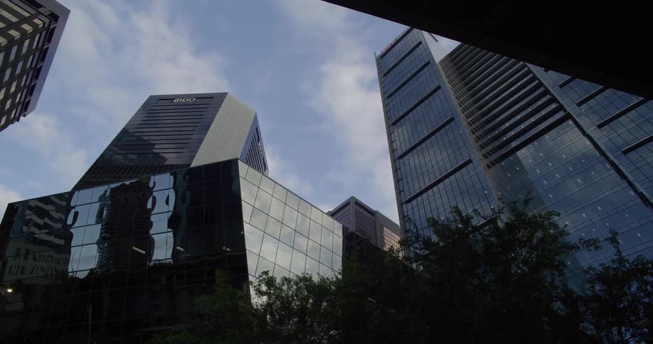 Buildings in a downtown area reflect the clouds in the sky