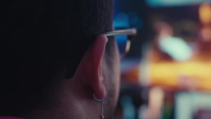 A man wearing glasses is watching a tv show
