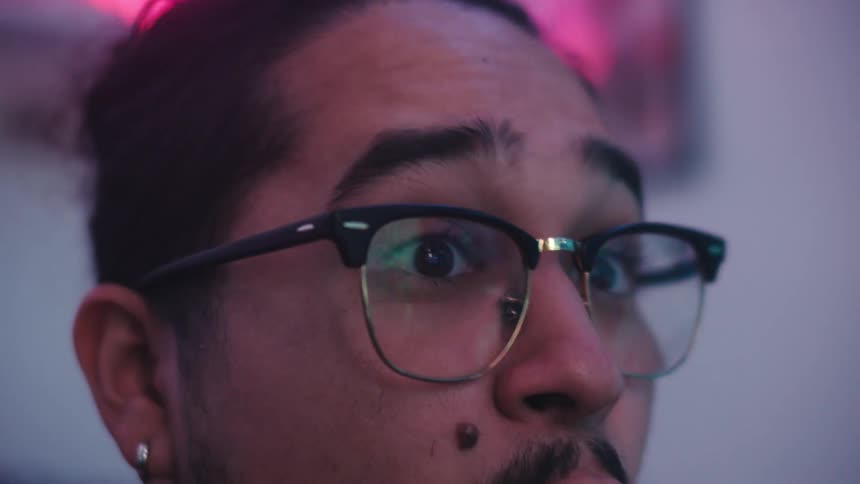 A man with headphones around his neck is surprised
