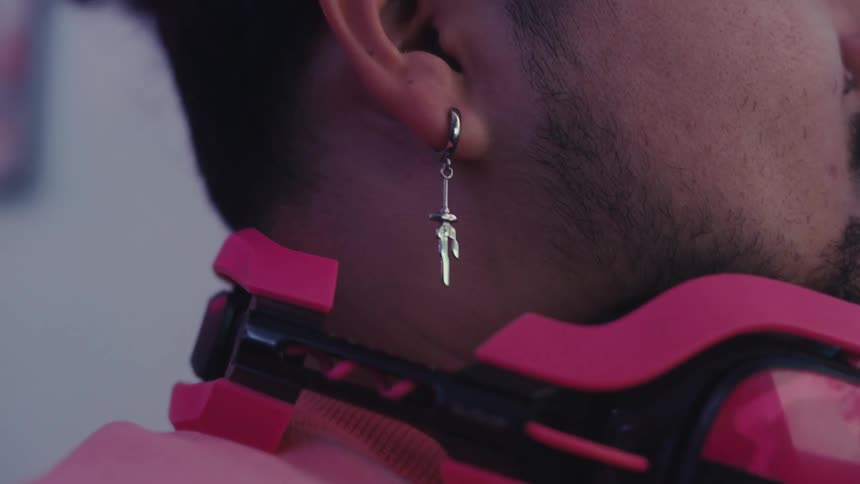 The ear of a bearded man wearing a silver earring