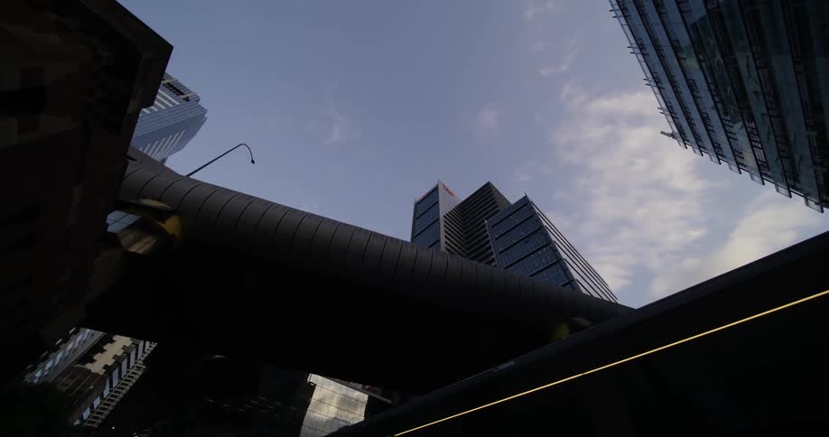 Upward view of modern skyscrapers in a metropolis against a partly cloudy sky