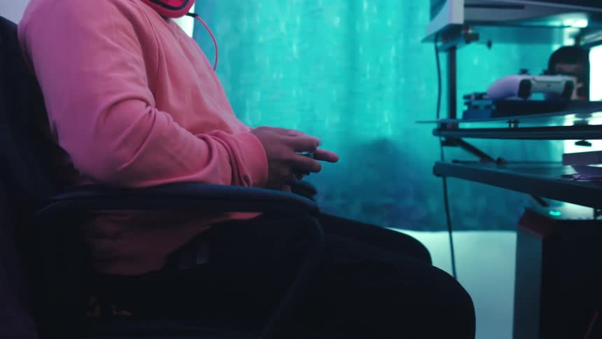 Person sitting playing video game on a wireless controller