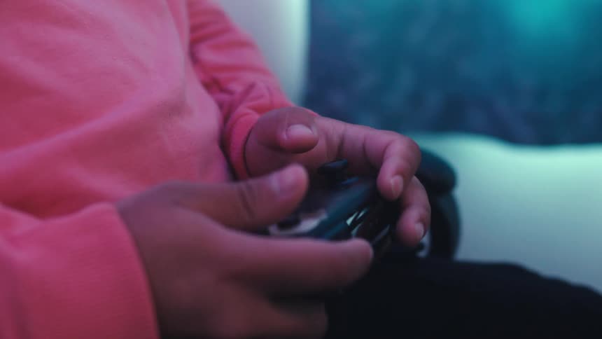 Pair of hands holding a wireless video game controller and interacting