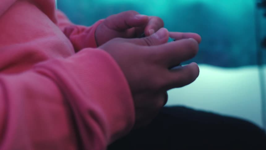 Hands holding and playing with a black video game controller